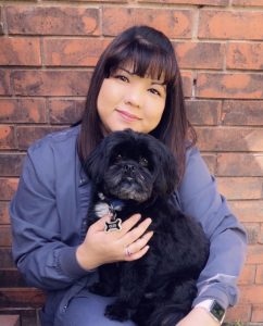 Yayoi Usry Customer Relation Manager holding a dog